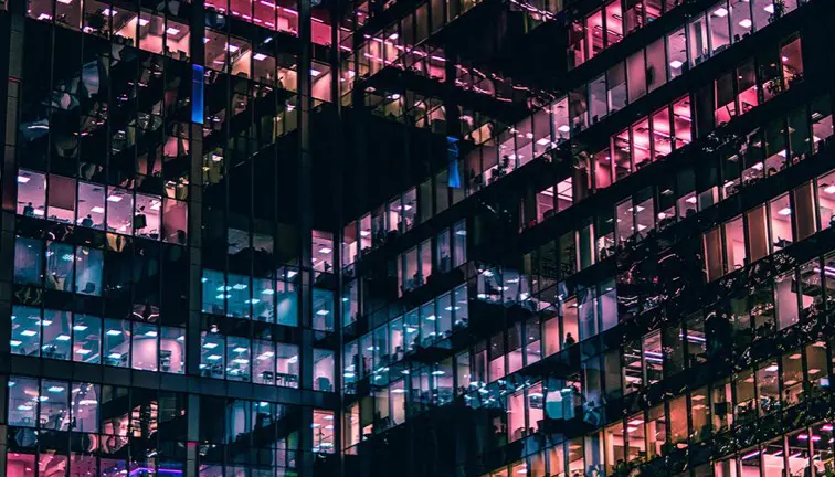 Apartment building with pink and blue lights from windows